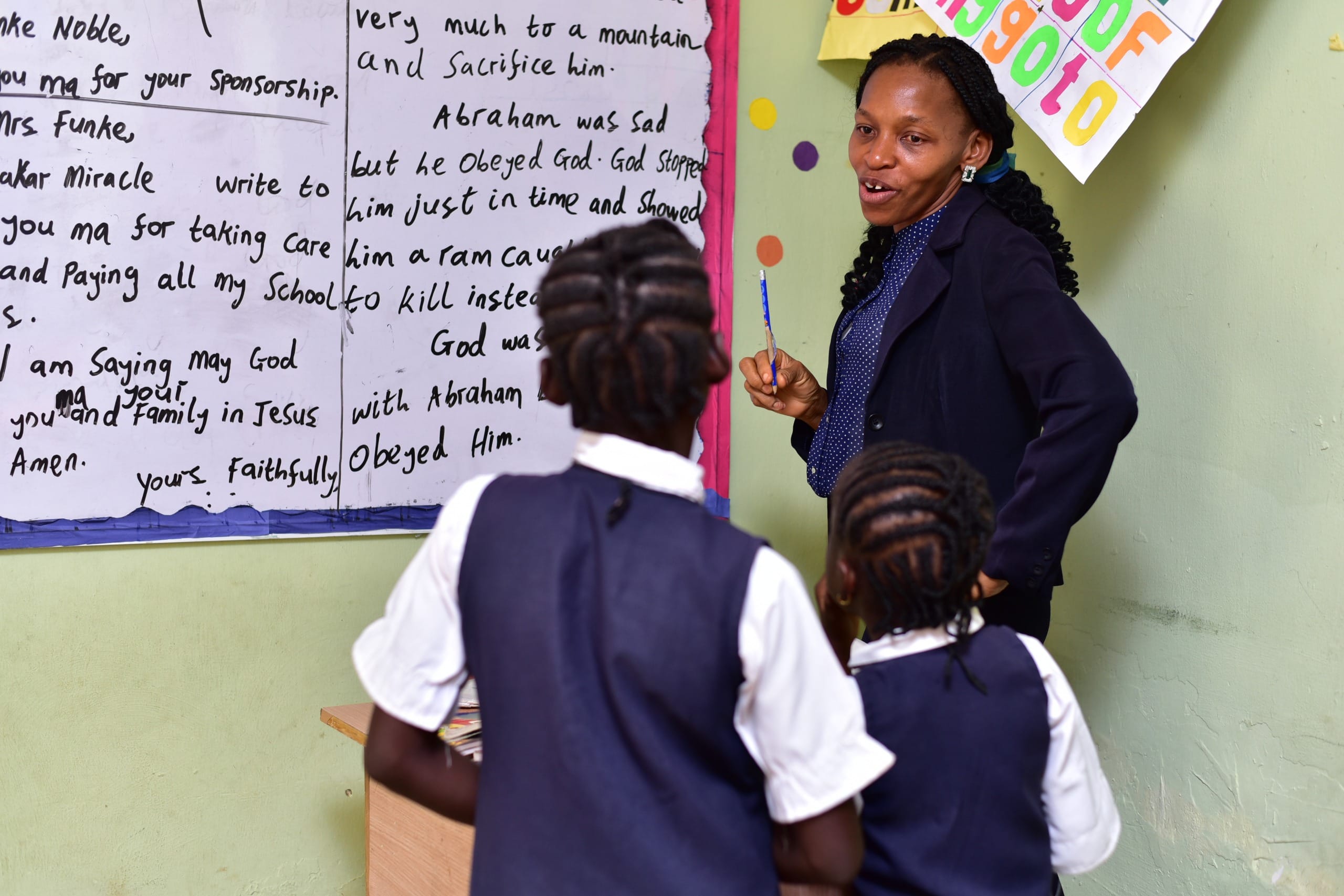 A teacher guiding pupils at a classroom board