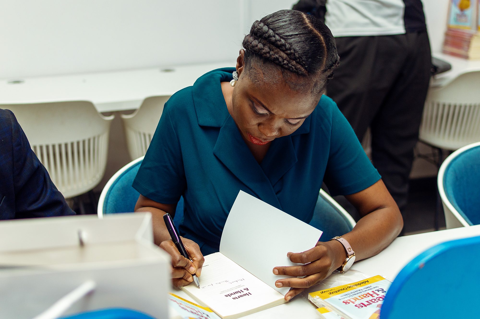 Adedolapo Osuntuyi signing a copy of Hearts & Hands at the Edufuture Conference 2024